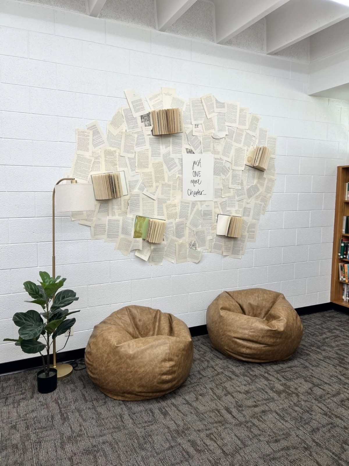 Bean bag chairs beneath a wall collage of book pages at the library