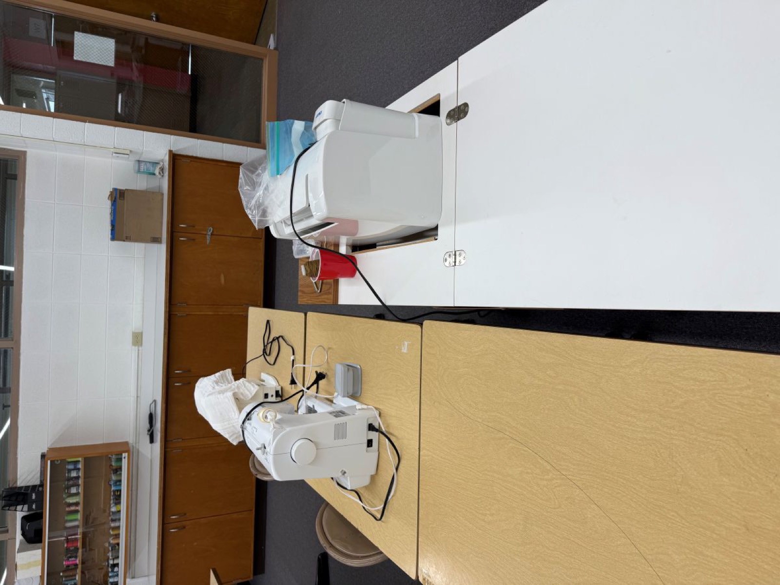 Two sewing stations with machines and a cutting surface