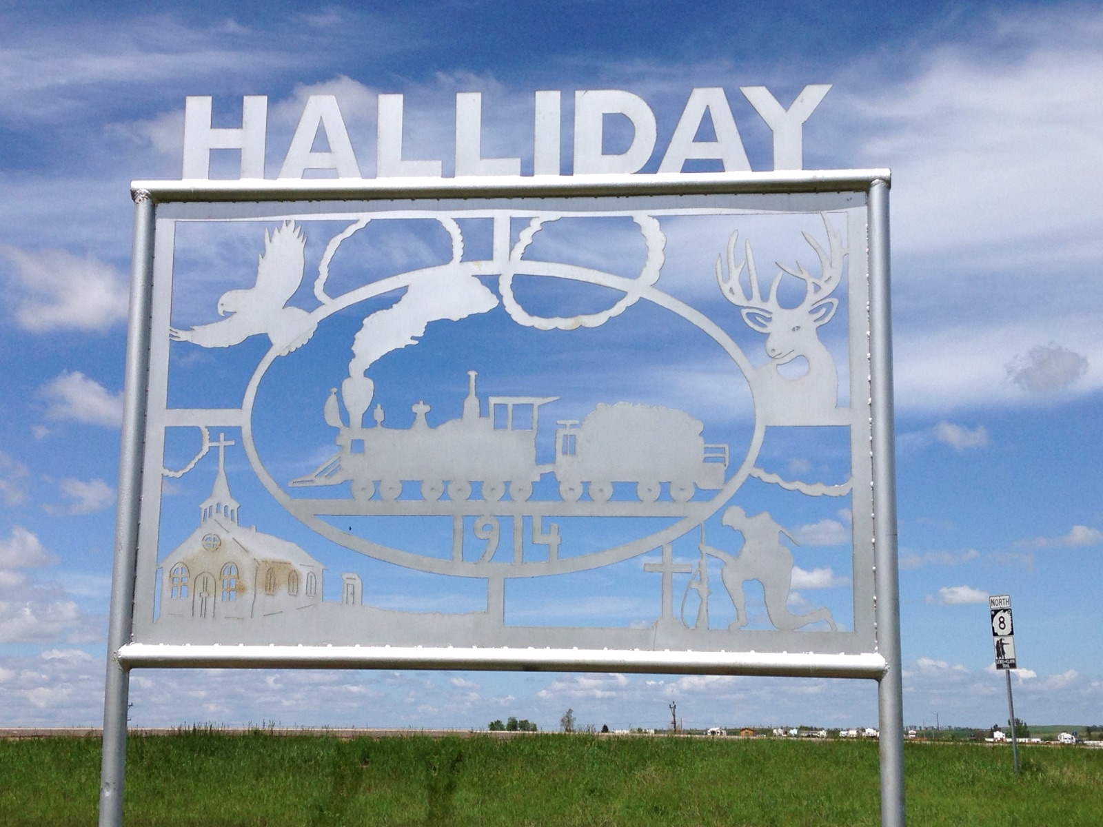 Halliday city welcome sign against a blue sky